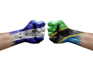 Two hands punch to each others on white background. Country flags painted fists, conflict crisis concept between honduras and tanzania