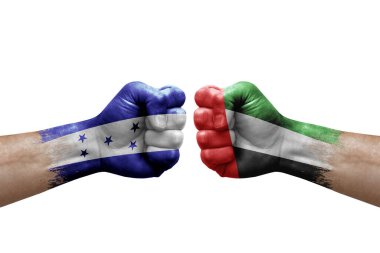 Two hands punch to each others on white background. Country flags painted fists, conflict crisis concept between honduras and united arab emirates