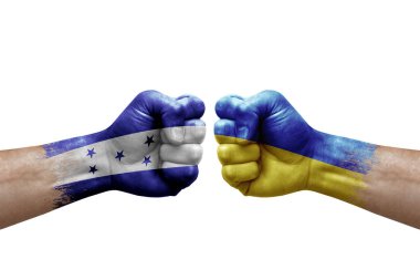 Two hands punch to each others on white background. Country flags painted fists, conflict crisis concept between honduras and ukraine