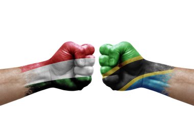 Two hands punch to each others on white background. Country flags painted fists, conflict crisis concept between hungary and tanzania