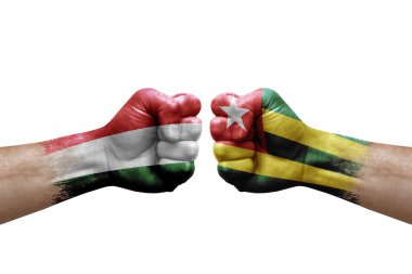 Two hands punch to each others on white background. Country flags painted fists, conflict crisis concept between hungary and togo