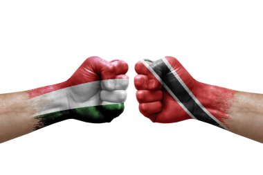 Two hands punch to each others on white background. Country flags painted fists, conflict crisis concept between hungary and tobago