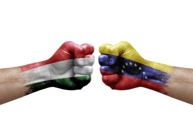 Two hands punch to each others on white background. Country flags painted fists, conflict crisis concept between hungary and venezuela