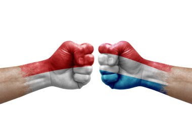 Two hands punch to each others on white background. Country flags painted fists, conflict crisis concept between indonesia and luxembourg