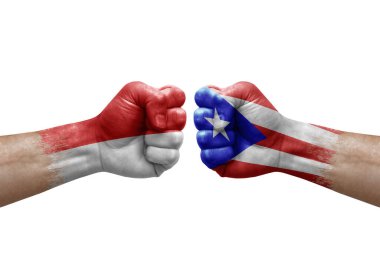 Two hands punch to each others on white background. Country flags painted fists, conflict crisis concept between indonesia and puerto rico