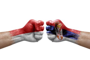 Two hands punch to each others on white background. Country flags painted fists, conflict crisis concept between indonesia and serbia