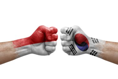 Two hands punch to each others on white background. Country flags painted fists, conflict crisis concept between indonesia and south korea