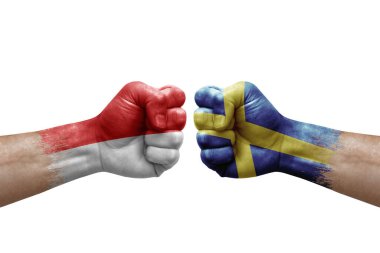 Two hands punch to each others on white background. Country flags painted fists, conflict crisis concept between indonesia and sweden