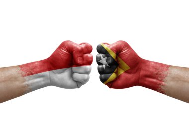 Two hands punch to each others on white background. Country flags painted fists, conflict crisis concept between indonesia and timor leste