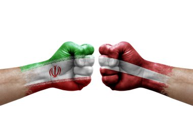 Two hands punch to each others on white background. Country flags painted fists, conflict crisis concept between iran and latvia
