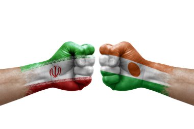 Two hands punch to each others on white background. Country flags painted fists, conflict crisis concept between iran and niger