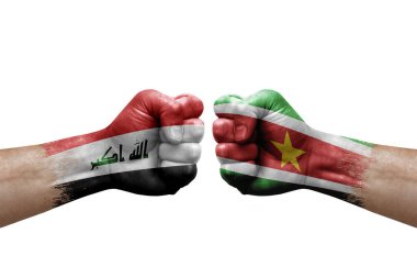 Two hands punch to each others on white background. Country flags painted fists, conflict crisis concept between iraq and suriname