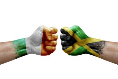 Two hands punch to each others on white background. Country flags painted fists, conflict crisis concept between ireland and jamaica