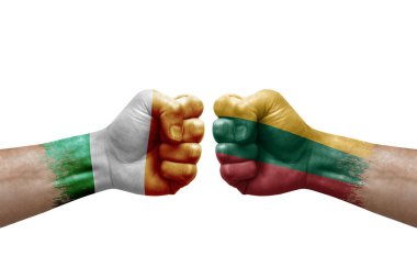 Two hands punch to each others on white background. Country flags painted fists, conflict crisis concept between ireland and lithuania