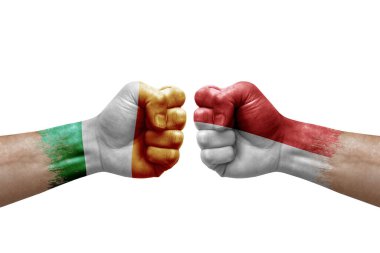 Two hands punch to each others on white background. Country flags painted fists, conflict crisis concept between ireland and monaco