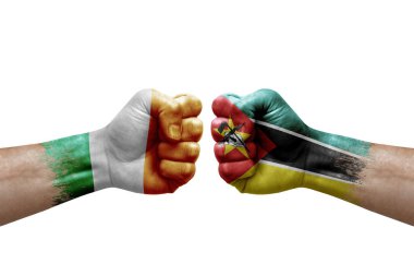 Two hands punch to each others on white background. Country flags painted fists, conflict crisis concept between ireland and mozambique