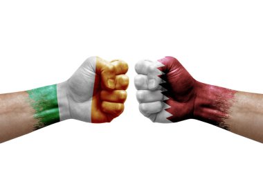 Two hands punch to each others on white background. Country flags painted fists, conflict crisis concept between ireland and qatar