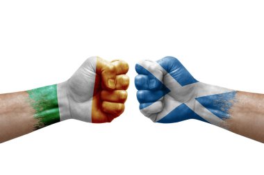 Two hands punch to each others on white background. Country flags painted fists, conflict crisis concept between ireland and scotland
