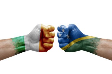Two hands punch to each others on white background. Country flags painted fists, conflict crisis concept between ireland and solomon islands