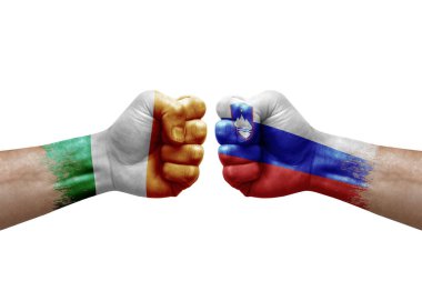 Two hands punch to each others on white background. Country flags painted fists, conflict crisis concept between ireland and slovenia