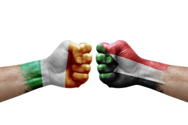 Two hands punch to each others on white background. Country flags painted fists, conflict crisis concept between ireland and sudan