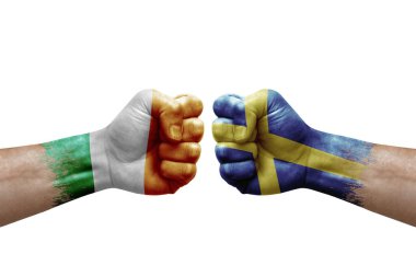Two hands punch to each others on white background. Country flags painted fists, conflict crisis concept between ireland and sweden