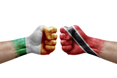 Two hands punch to each others on white background. Country flags painted fists, conflict crisis concept between ireland and tobago
