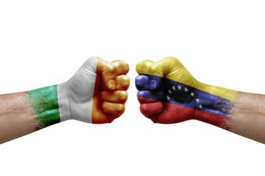 Two hands punch to each others on white background. Country flags painted fists, conflict crisis concept between ireland and venezuela