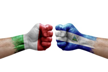 Two hands punch to each others on white background. Country flags painted fists, conflict crisis concept between italy and nicaragua