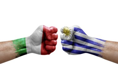 Two hands punch to each others on white background. Country flags painted fists, conflict crisis concept between italy and uruguay