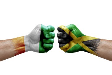 Two hands punch to each others on white background. Country flags painted fists, conflict crisis concept between ivory coast and jamaica