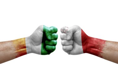 Two hands punch to each others on white background. Country flags painted fists, conflict crisis concept between ivory coast and malta