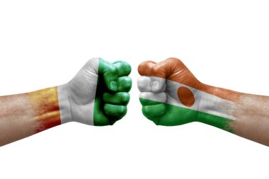 Two hands punch to each others on white background. Country flags painted fists, conflict crisis concept between ivory coast and niger