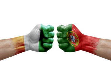 Two hands punch to each others on white background. Country flags painted fists, conflict crisis concept between ivory coast and portugal
