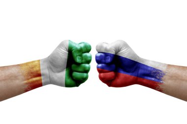 Two hands punch to each others on white background. Country flags painted fists, conflict crisis concept between ivory coast and russia