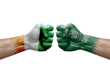 Two hands punch to each others on white background. Country flags painted fists, conflict crisis concept between ivory coast and saudi arabia