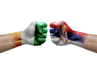 Two hands punch to each others on white background. Country flags painted fists, conflict crisis concept between ivory coast and serbia
