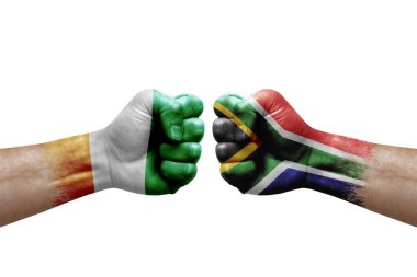 Two hands punch to each others on white background. Country flags painted fists, conflict crisis concept between ivory coast and south africa