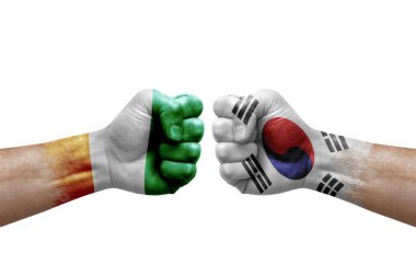 Two hands punch to each others on white background. Country flags painted fists, conflict crisis concept between ivory coast and south korea