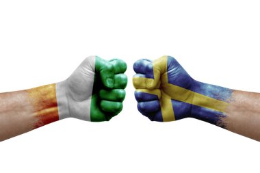 Two hands punch to each others on white background. Country flags painted fists, conflict crisis concept between ivory coast and sweden