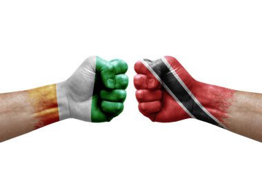 Two hands punch to each others on white background. Country flags painted fists, conflict crisis concept between ivory coast and tobago