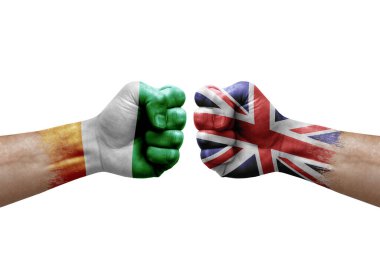 Two hands punch to each others on white background. Country flags painted fists, conflict crisis concept between ivory coast and united kingdom
