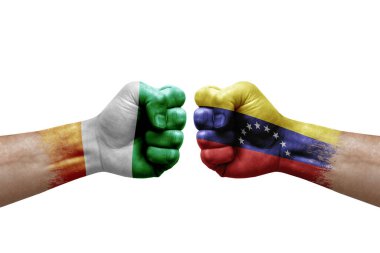 Two hands punch to each others on white background. Country flags painted fists, conflict crisis concept between ivory coast and venezuela
