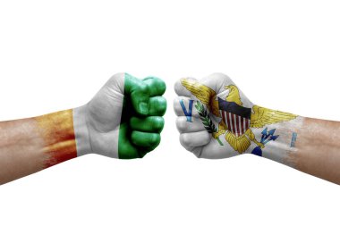 Two hands punch to each others on white background. Country flags painted fists, conflict crisis concept between ivory coast and virgin islands