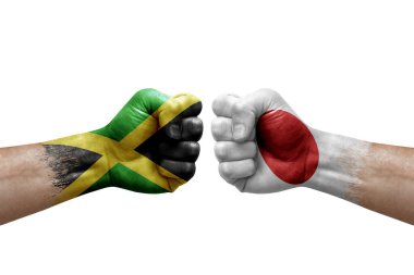 Two hands punch to each others on white background. Country flags painted fists, conflict crisis concept between jamaica and japan