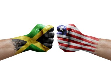 Two hands punch to each others on white background. Country flags painted fists, conflict crisis concept between jamaica and liberia