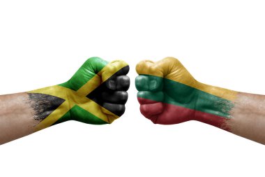 Two hands punch to each others on white background. Country flags painted fists, conflict crisis concept between jamaica and lithuania