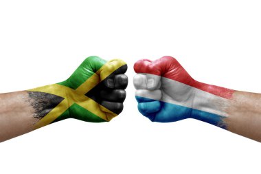 Two hands punch to each others on white background. Country flags painted fists, conflict crisis concept between jamaica and luxembourg