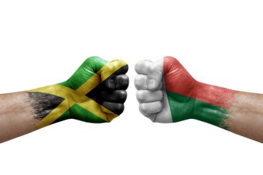 Two hands punch to each others on white background. Country flags painted fists, conflict crisis concept between jamaica and madagascar