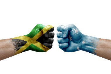 Two hands punch to each others on white background. Country flags painted fists, conflict crisis concept between jamaica and micronesia